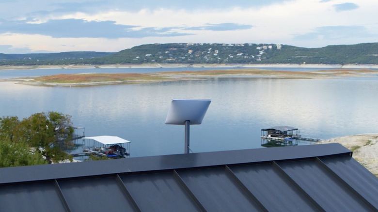 Starlink dish on rooftop overlooking lake and homes
