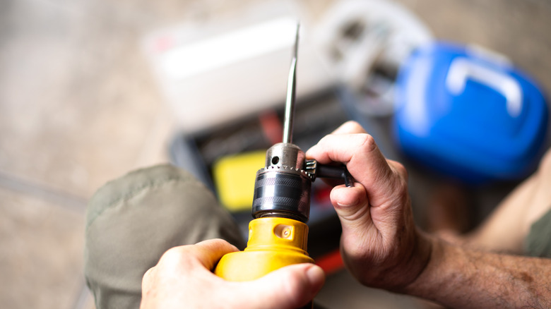 Man tightening chuck on drill