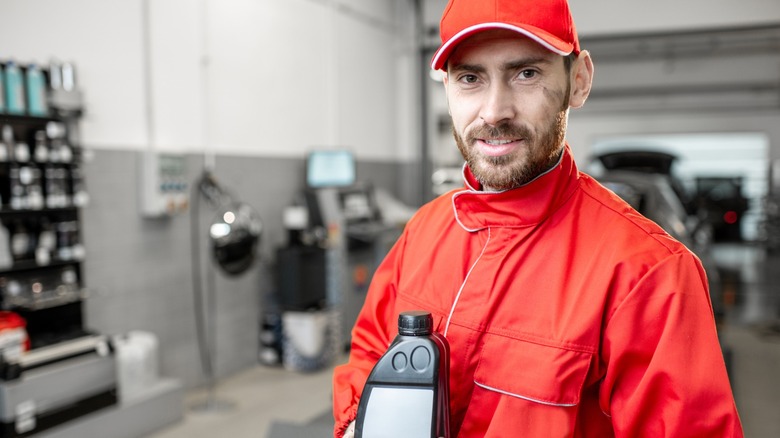 Mechanic holding a bottle of motor oil