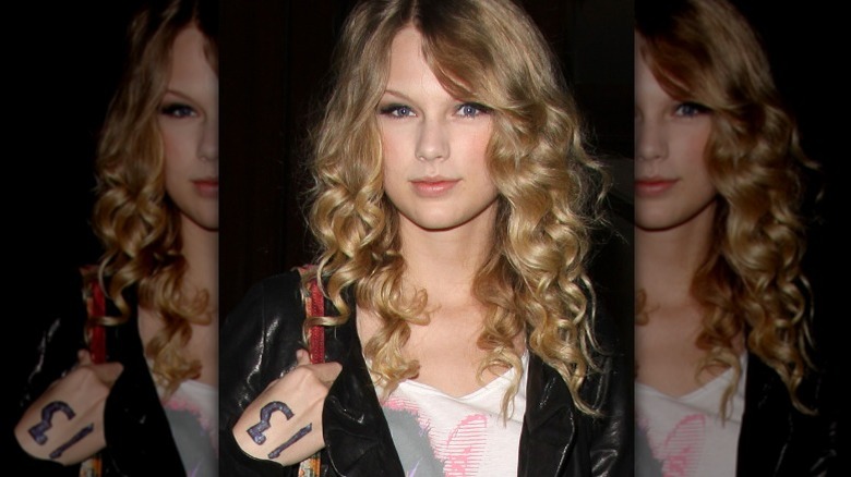 Taylor Swift with the number 13 boldly written on her hand