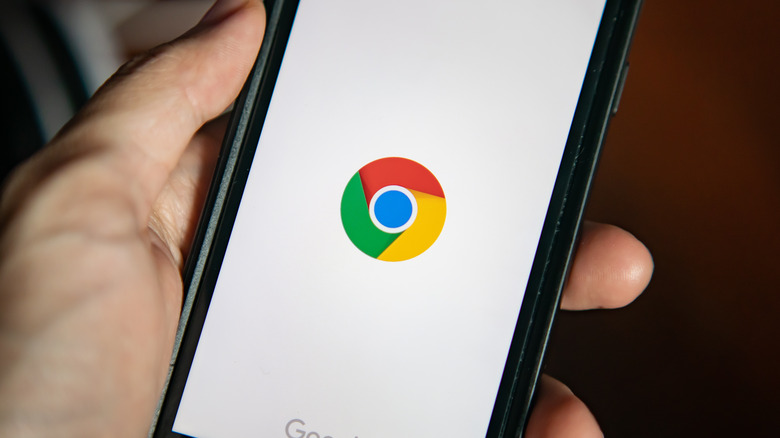 hand holding phone with Chrome Logo