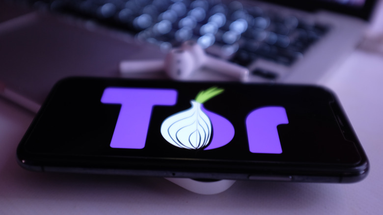 The Tor logo on a phone, laying on a laptop