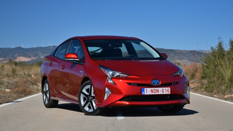 Red Toyota Prius parked on a road