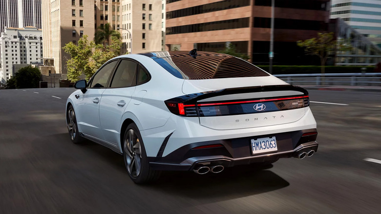 A while Hyundai Sonata driving in a city