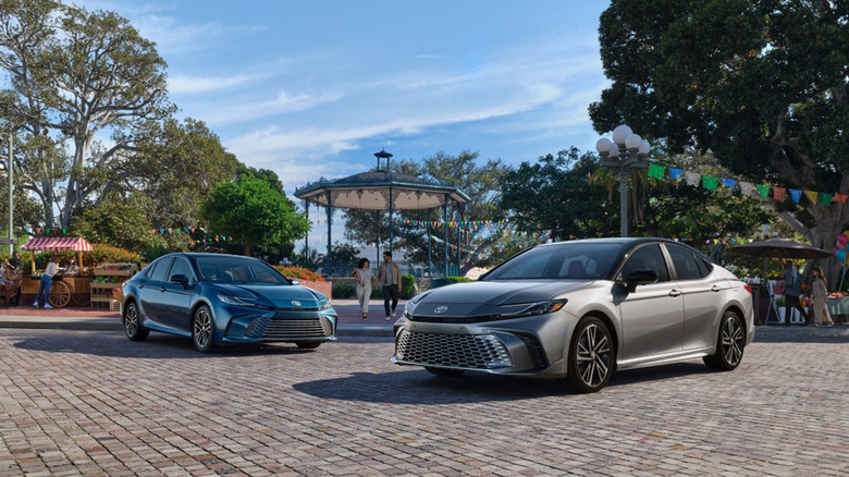 Two Toyota Camry cars packed on a brick road