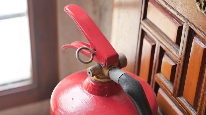 a fire extinguisher placed next to wooden furniture in a home