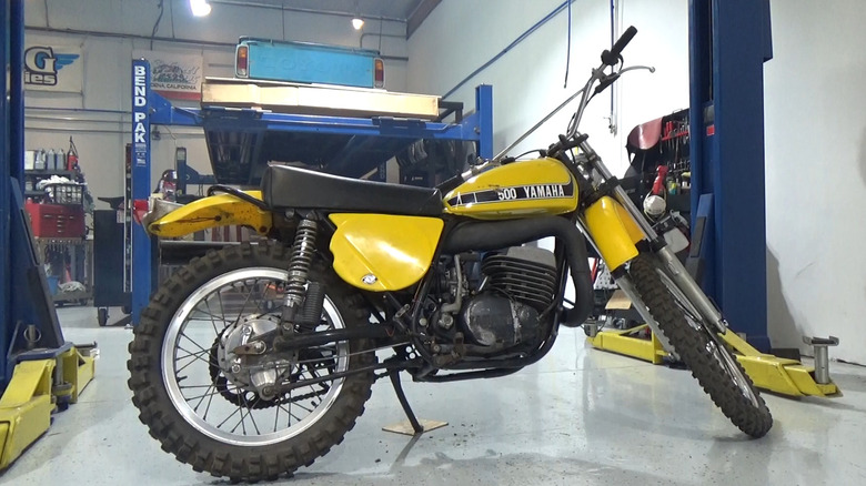 A yellow Yamaha SC 500 Scrambler parked on its stand inside a garage.