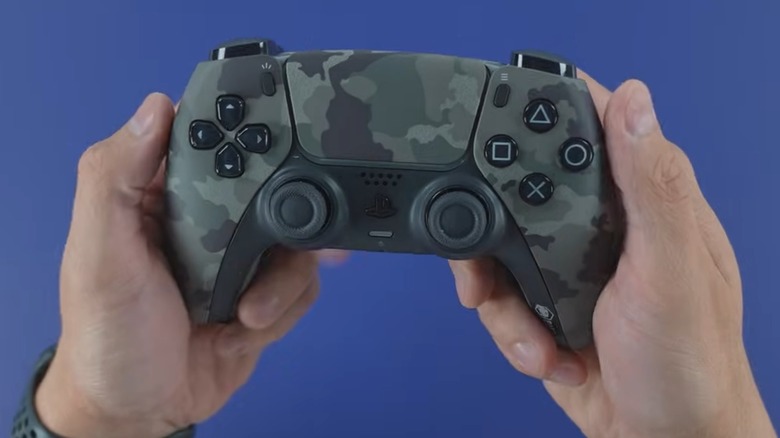 A person holding a Battle Beaver custom PS5 controller.