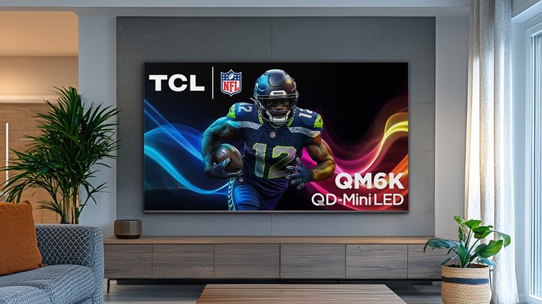 A TCL 75QM6K TV attached to a wall in living room