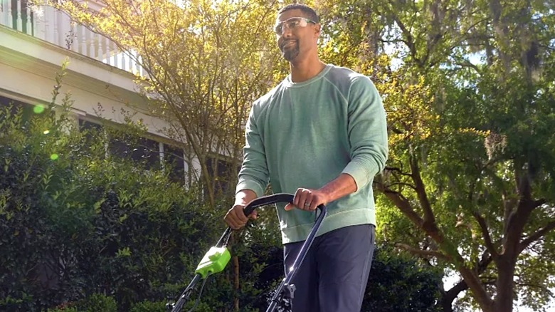 Person pushing Greenworks lawnmower