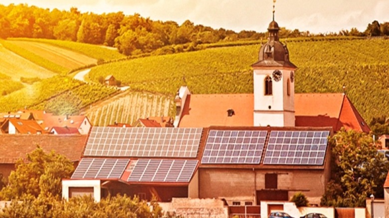 A church building outfitted with a solar panel array on its roof.