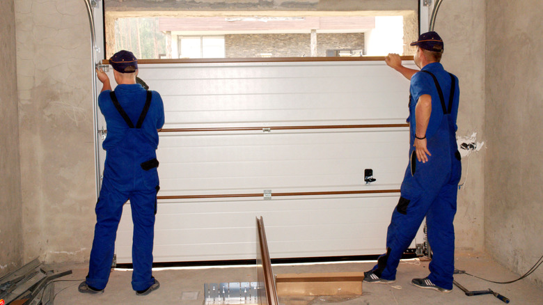 Contractors insulating garage door.s