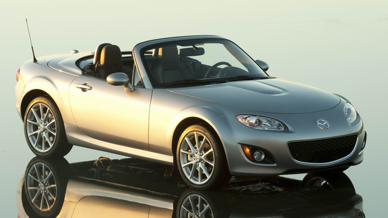 A 2010 silver Mazda Miata convertible parked showing its front fascia
