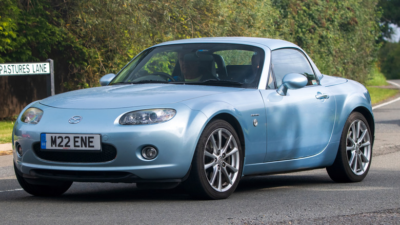 A blue 2008 Mazda Miata parked on the road