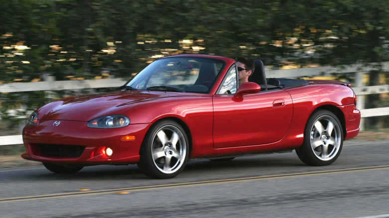 A red 2005 Mazdaspeed Miata MX-5 in action on road