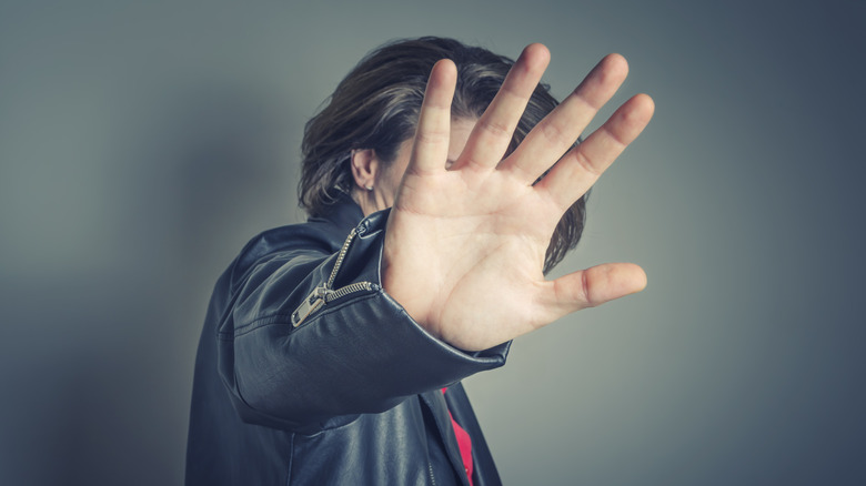 Person blocking face with hand