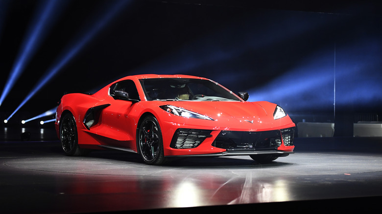 A Chevrolet Corvette C8 at the official reveal, front 3/4 view, red exterior