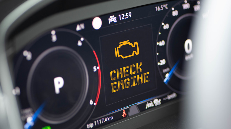 A close-up of a car's dashboard with a large yellow Check Engine notification displayed