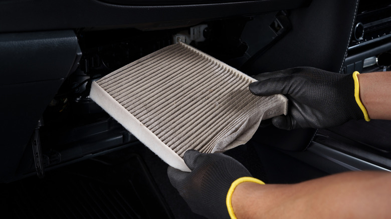 Mechanic replacing a cabin filter