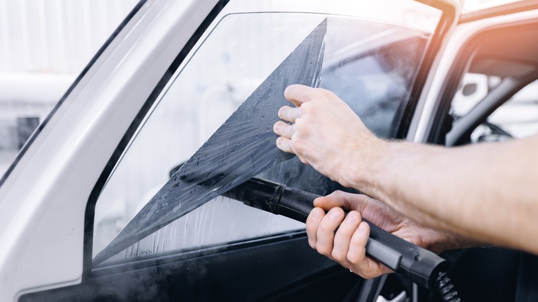 Person removing window tint film
