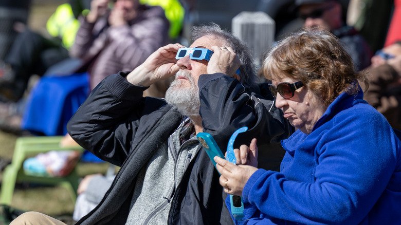 People use special glasses to view a solar eclipse.