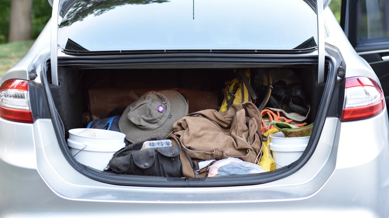 A sedan trunk filled with items and goods for a trip.