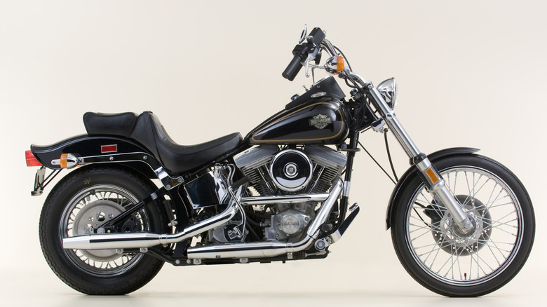 A black Harley Davidson FXST Softail on display against a cream background