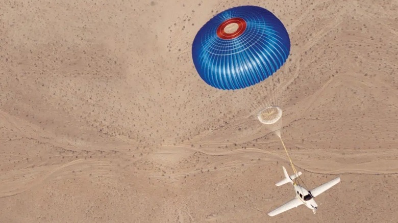 Cirrus airplane with CAPS system deployed over a desert