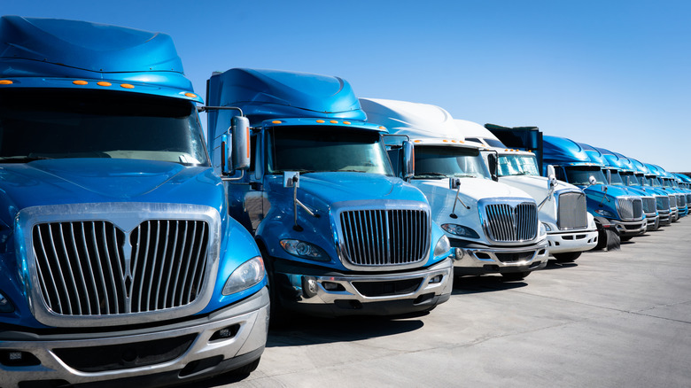 Large fleet of commercial trucks 18 wheelers parked in truck yard