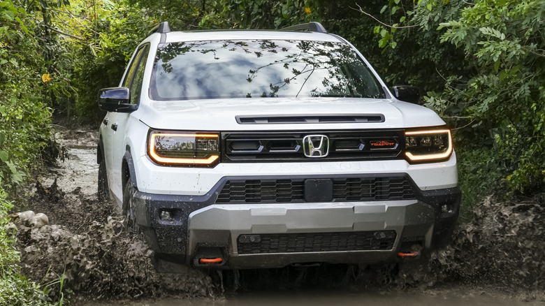 Front 3/4 view of Honda Passport on muddy off-road trail