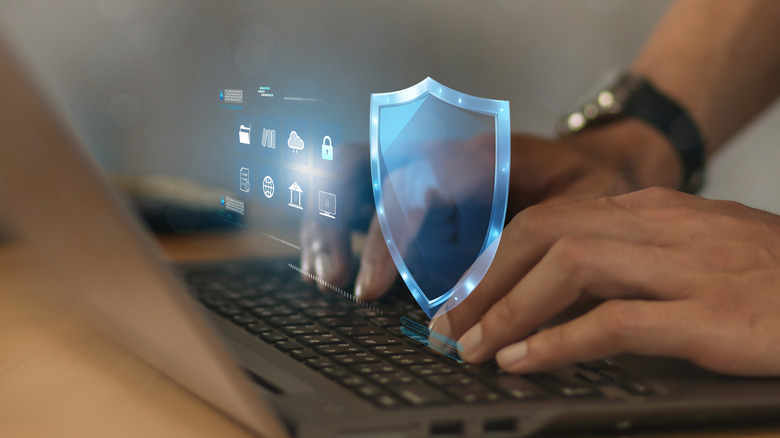 Close up of man using laptop with security logo