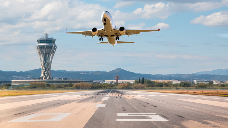 A plane taking off on a runway with numer on it