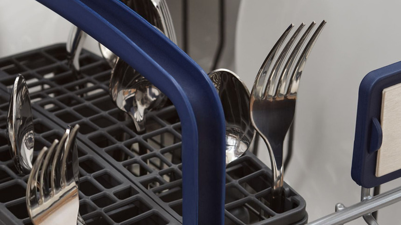 A Viking dishwasher interior with clean dishes and a cutlery basket.