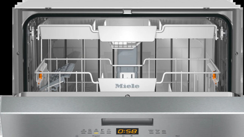 A silver Miele dishwasher with its door open.