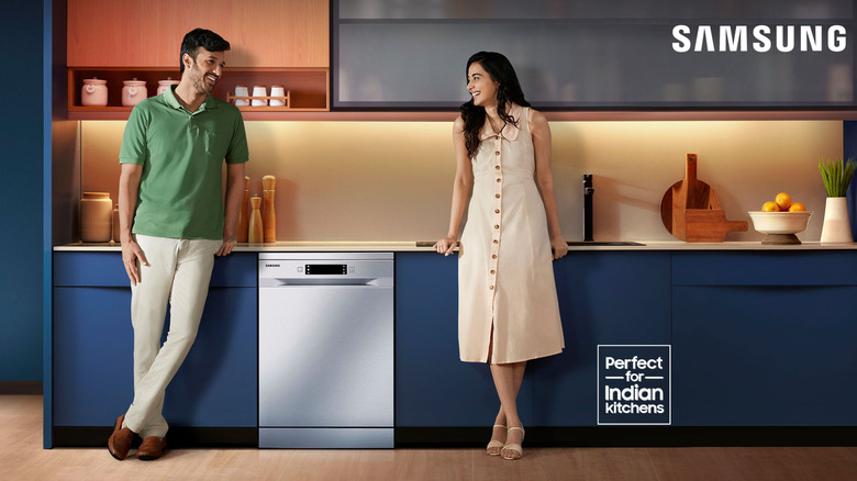 A couple in a kitchen with their Samsung dishwasher.