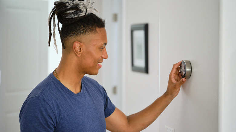 Person using heating function on their thermostat