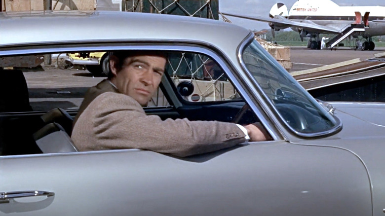 James Bond looking out the window of his Aston Martin