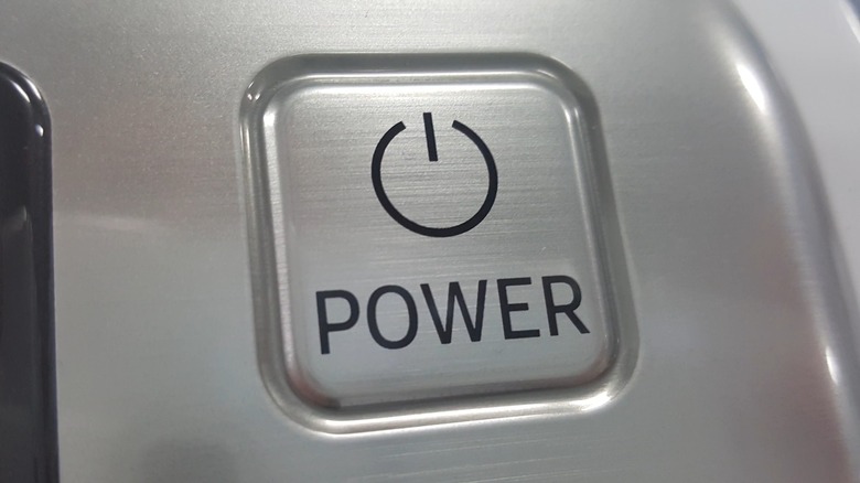 A silver power button on a home appliance