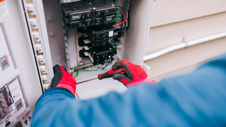 Two hands install connect solar panels to electricity