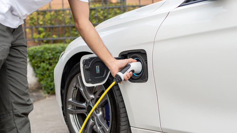 A person plugging a charger into their EV
