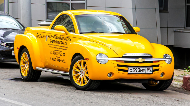 A yellow Chevy SSR parked outside. 