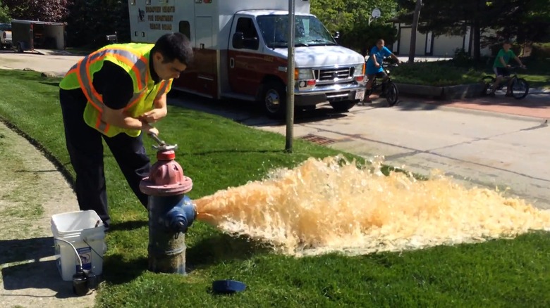 a fire fighter flushing a fire hydrant