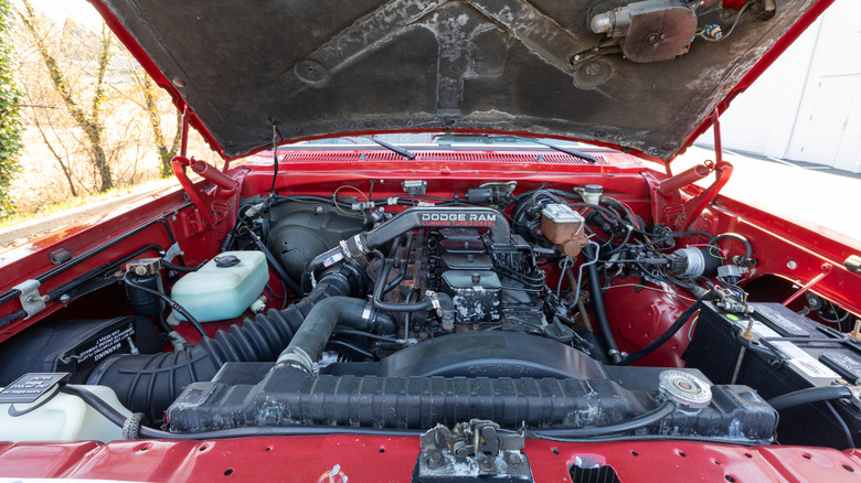 A Cummins turbo diesel under the hood of an older Dodge Ram, red exterior