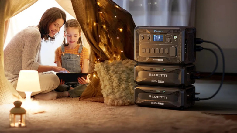 Mother and daughter using Bluetti portable power station indoors