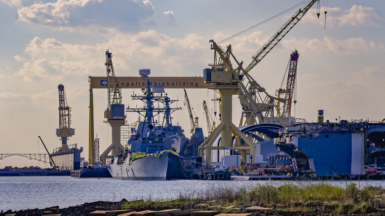 Cranes and naval ships at a naval shipyard