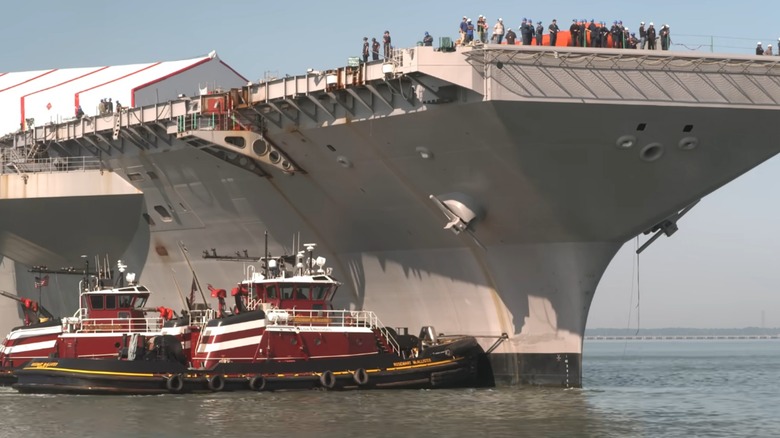 USS John F. Kennedy being moved by tug boats