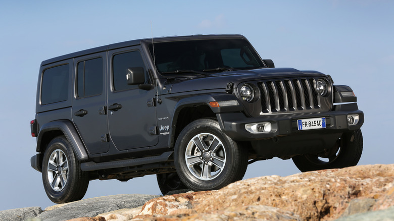 Charcoal grey Jeep Wrangler on jetty rocks