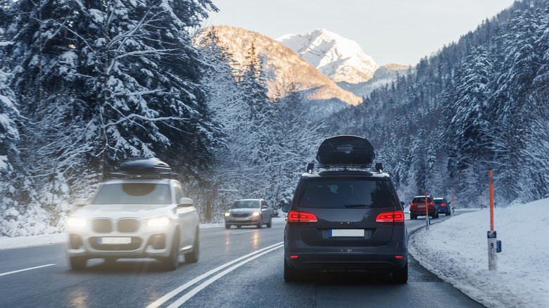 Selection of cars driving on a mountain road in the snow
