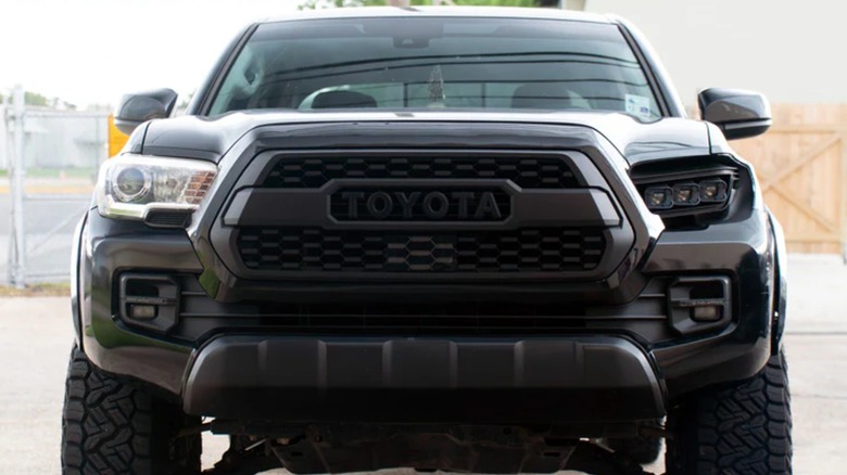 Front view of a Toyota Tacoma with a traditional and lensless headlight.