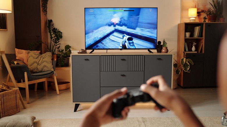 A Person Playing Video Games On A Living Room Flat Screen TV
